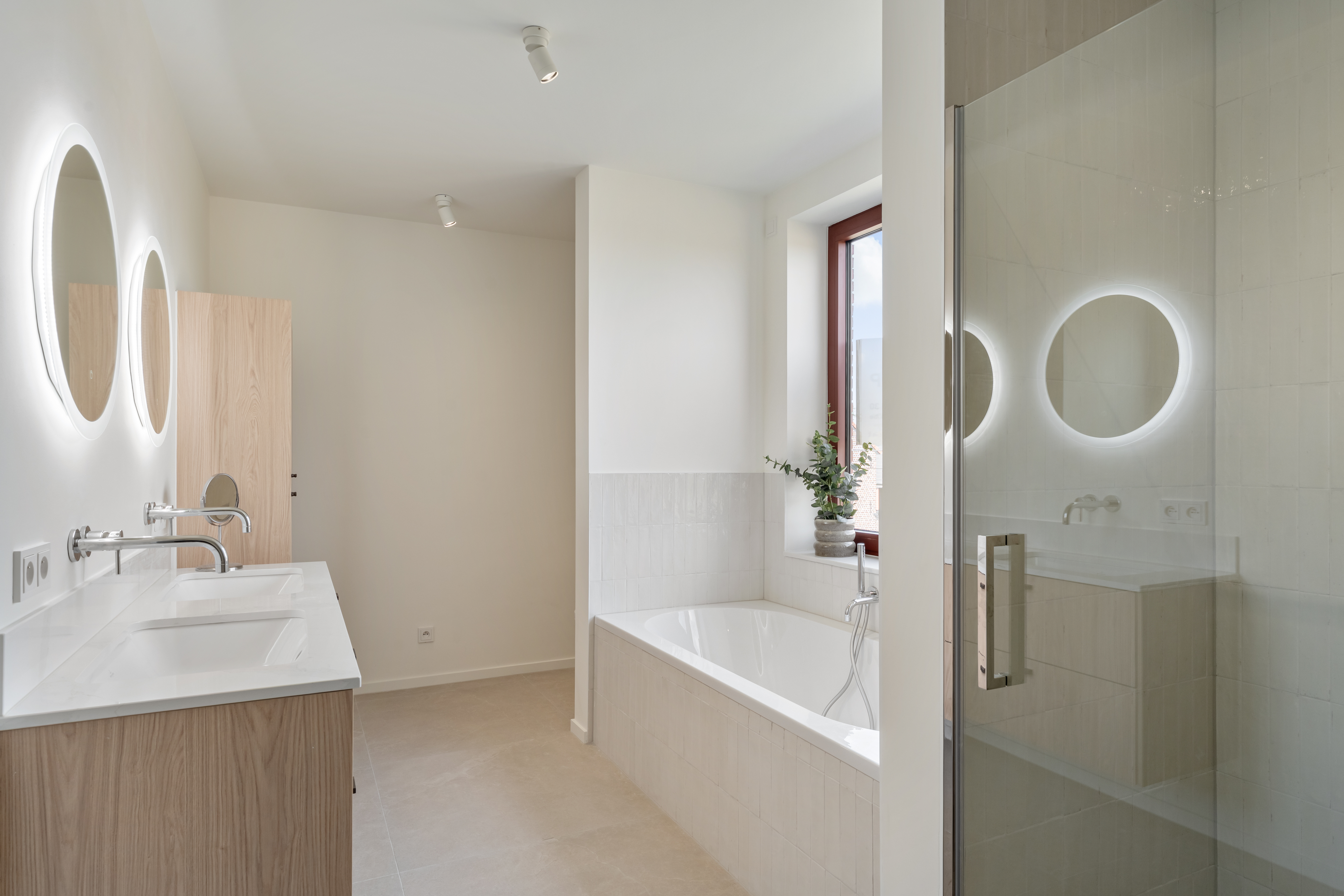 Badkamer met dubbele wastafel, ligbad en inloopdouche